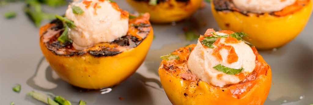 Duraznos a la parrilla con queso crema y almendras